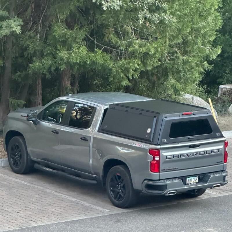 ovs-expedition-truck-cap-for-chevrolet-silverado-1500-black-rear-view-on-chevy-silverado-in-parking-space
