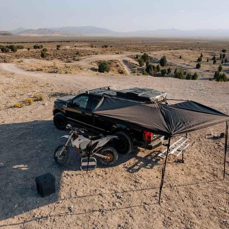 roam-arc-270-awning-driver-side-open-drone-view-with-motorcyle-in-nature