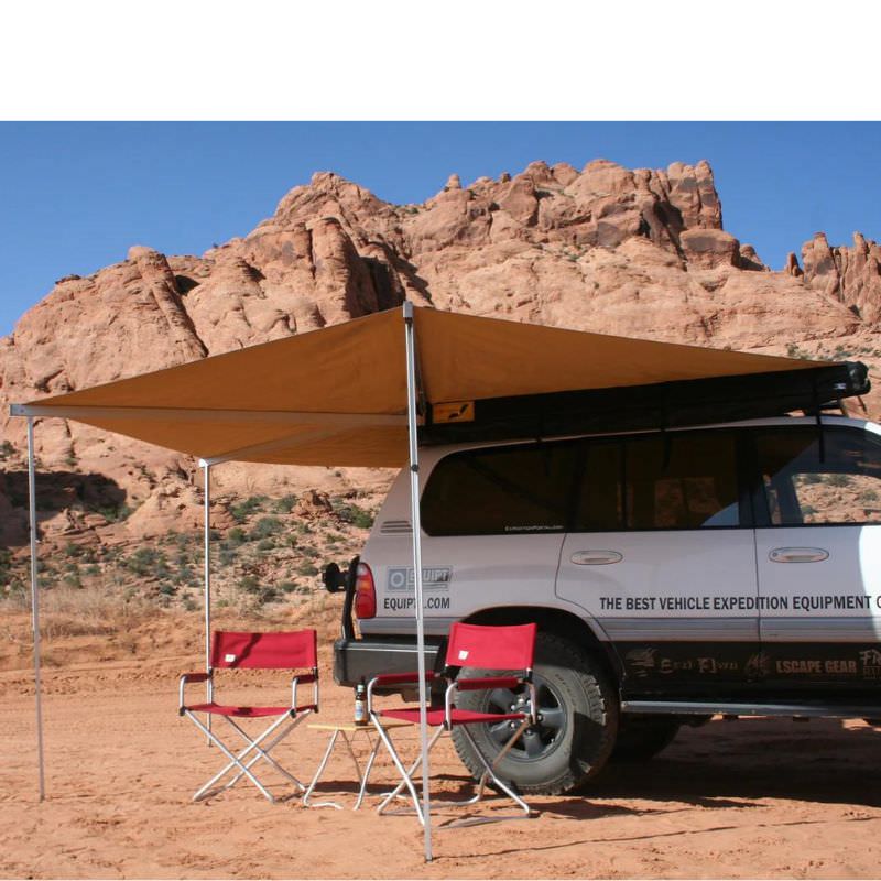 eezi-awn-bat-270-awning-beige-open-rear-side-view-ontop-of-land-cuiser-in-terrain-with-red-folding-chairs