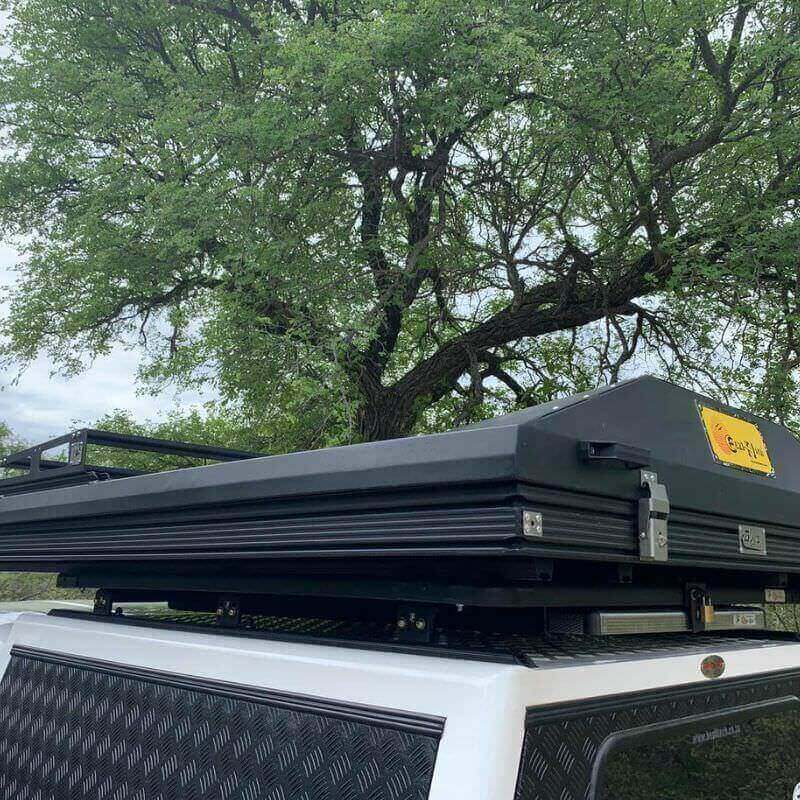 eezi-awn-blade-40th-edition-hard-shell-roof-top-tent-closed-rear-corner-view-on-vehicle-in-nature