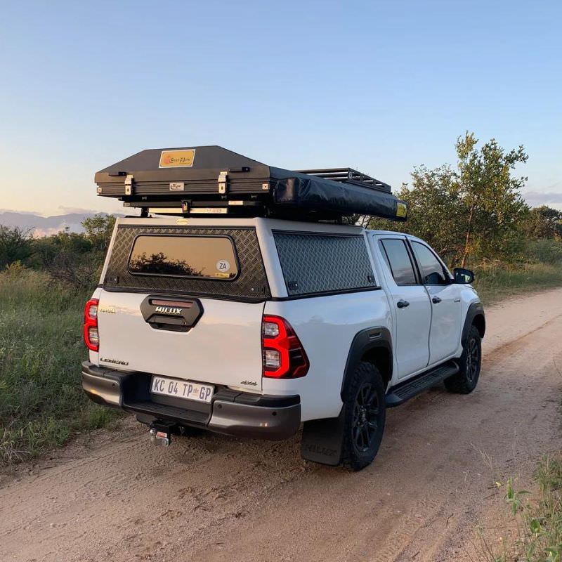 eezi-awn-blade-40th-edition-hard-shell-roof-top-tent-closed-rear-corner-view-on-vehicle-in-safari-area