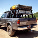 eezi-awn-jazz-soft-shell-roof-top-tent-closed-rear-corner-view-on-vehicle-with-cover-in-nature