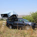 eezi-awn-jazz-soft-shell-roof-top-tent-open-side-view-on-vehicle-with-extended-ladder-in-the-fields