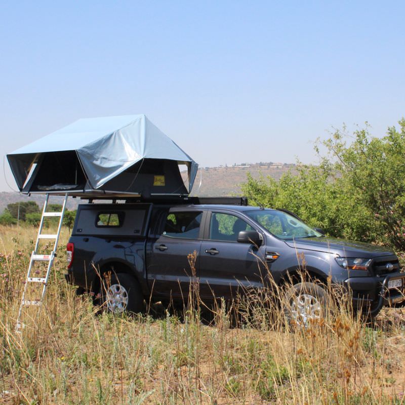 eezi-awn-jazz-soft-shell-roof-top-tent-open-side-view-on-vehicle-with-extended-ladder-in-the-fields