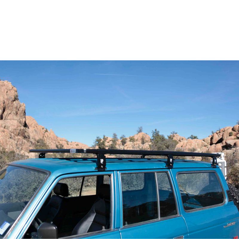 eezi-awn-k9-roof-rack-for-toyota-land-cruiser-60-close-up-view-with-roof-rack-legs-on-blue-land-cruiser-in-terrain`