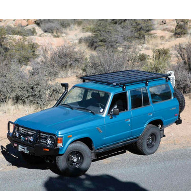 eezi-awn-k9-roof-rack-for-toyota-land-cruiser-60-front-corner-view-on-blue-land-cruiser-in-terrain
