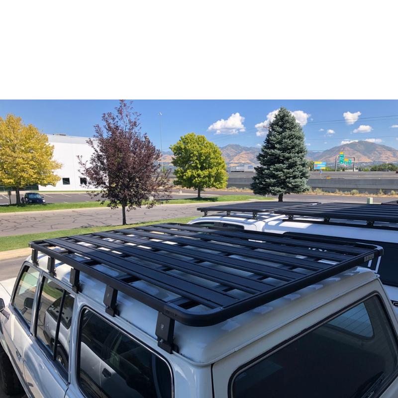 eezi-awn-k9-roof-rack-for-toyota-land-cruiser-60-rear-coner-veiw-with-trees-and-vehicles-on-parking-lot