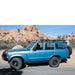eezi-awn-k9-roof-rack-for-toyota-land-cruiser-60-side-view-on-blue-land-cruiser-in-terrain