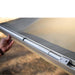 eezi-awn-lite-awning-beige-open-close-up-view-folded-aluminum-legs-in-nature