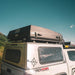 eezi-awn-sabre-hard-shell-roof-top-tent-closed-rear-corner-view-on-vehicle-with-latches-in-nature