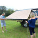 eezi-awn-series-1000-awning-beige-open-side-view-silver-hardcase-with-persons-on-land-cruiser-nature