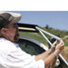 eezi-awn-series-2000-awning-open-side-view-person-setting-aluminum-arm-in-nature