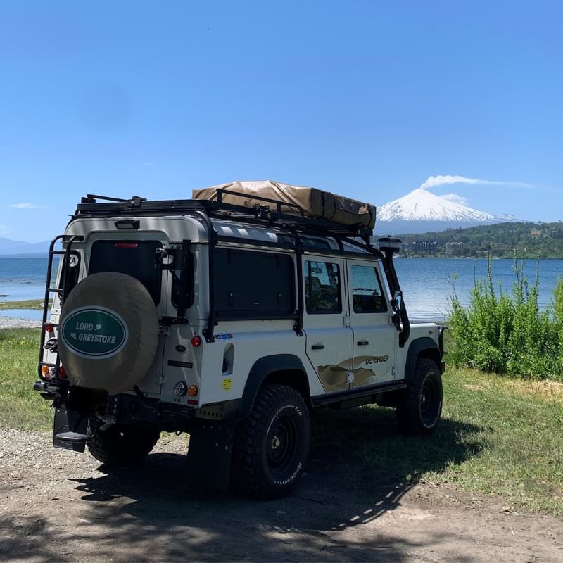 eezi-awn-series-3-roof-top-tent-beige-closed-rear-corner-view-on-land-rover-defender-facing-volcano