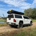 eezi-awn-sword-hard-shell-roof-top-tent-closed-rear-corner-view-on-vehicle-in-nature