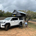 eezi-awn-sword-hard-shell-roof-top-tent-open-front-corner-view-on-vehicle-with-person-in-nature