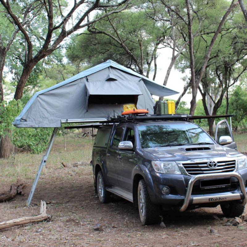 eezi-awn-xklusiv-soft-shell-roof-top-tent-gray-open-front-view-on-vehicle-with-extended-ladder-in-forest