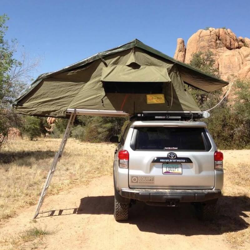 eezi-awn-xklusiv-soft-shell-roof-top-tent-olive-open-rear-view-on-vehicle-with-ladder-in-desert