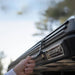 freespirit-recreation-aspen-v2-standard-hard-shell-roof-top-tent-black-closed-close-up-view-with-hand-holding-the-latch-in-nature