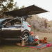 kammok-crosswing-awning-charcoal-5ft-open-front-corner-view-on-sedan-in-nature
