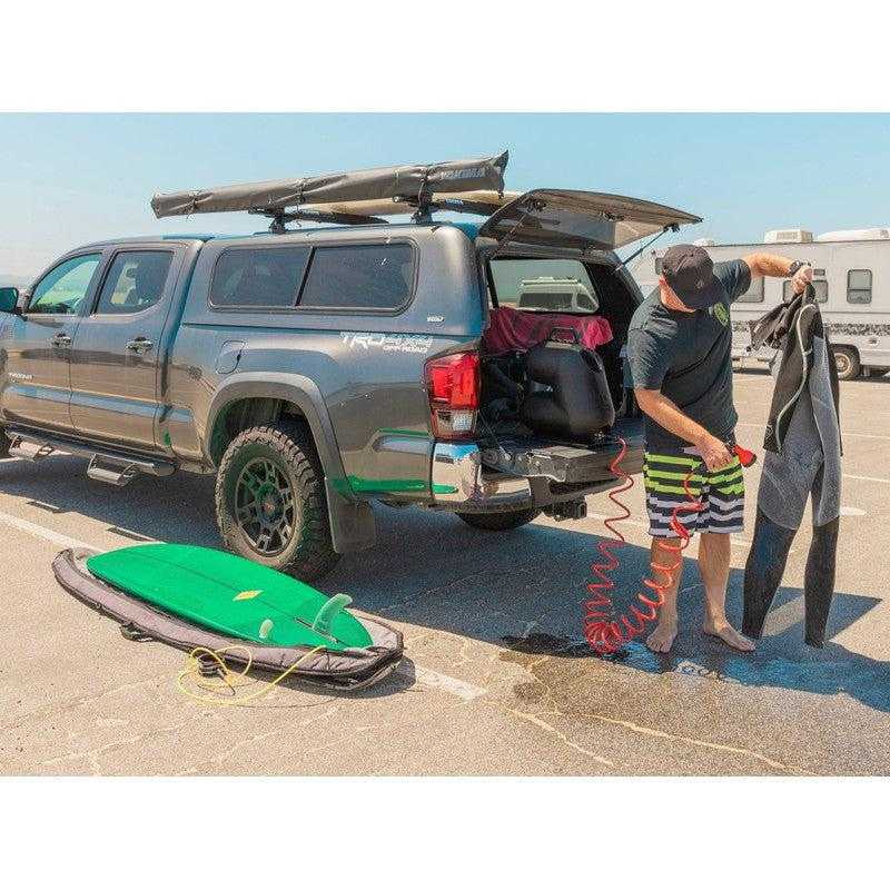 leitner-hydropod-carry-portable-shower-kit-side-view-inside-vehicle-with-person-washing-diving-suit-in-parking-space