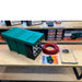 national-luna-dc-25-power-pack-green-top-view-with-inclusions-and-manual-on-table