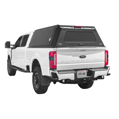 overland-vehicle-systems-expedition-truck-cap-black-for-2023-2024-ford-f250-f350-rear-corner-view-on-natural-backgound