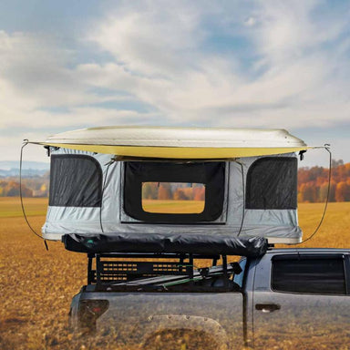 overland-vehicle-systems-hd-bundu-hard-shell-pop-up-roof-top-tent-gray-body-green-rainfly-open-side-view-on-vehicle-in-nature