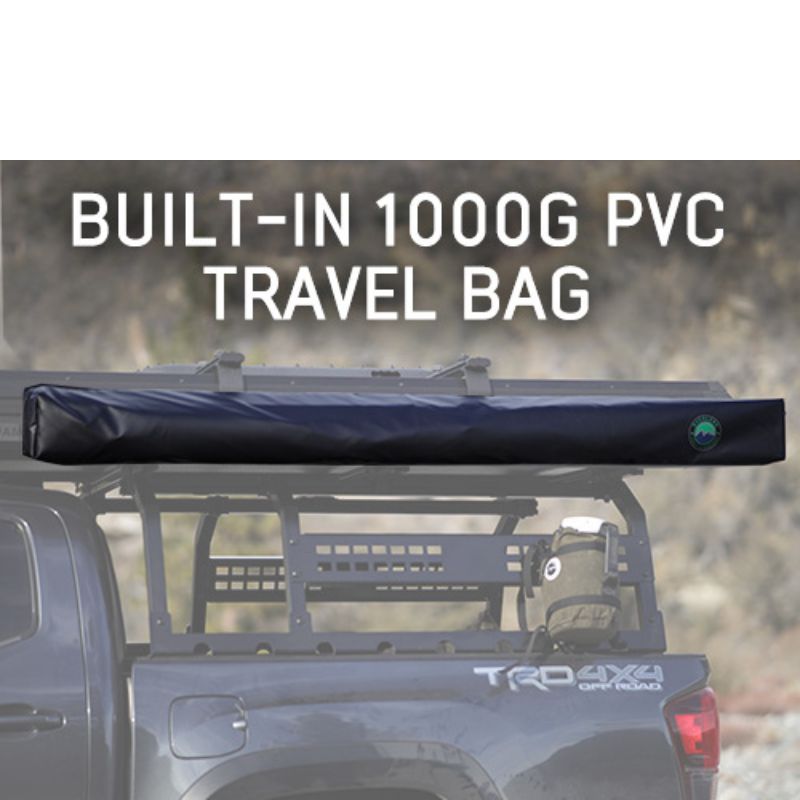 overland-vehicle-systems-nomadic-awning-180-lte-gray-closed-side-view-on-vehicle-with-pvc-travel-bag-in-nature