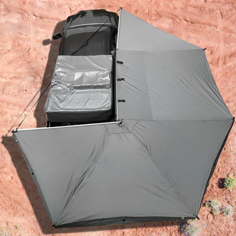 overland-vehicle-systems-nomadic-awning-270-for-mid-high-roofline-vans-passenger-side-open-drone view-on-toyota-tacoma-in-desert