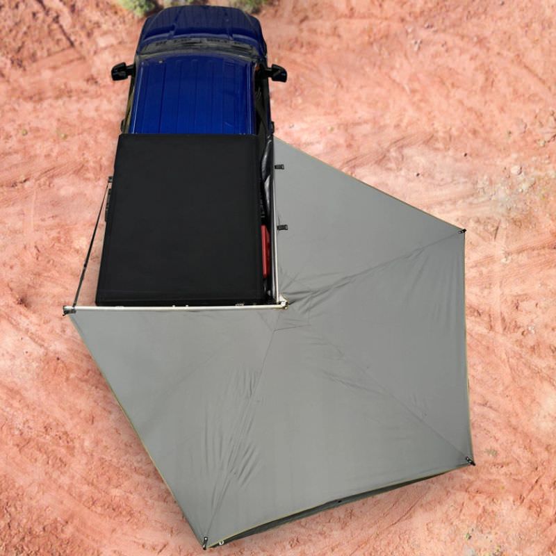 overland-vehicle-systems-nomadic-lt-270-awning-with-walls-dark-gray-passenger-side-open-drone-view-on-ford-ranger-in-desert