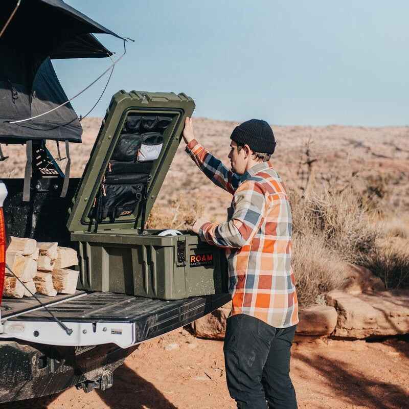 roam-105l-lid-organizer-front-corner-view-in-rugged-case-with-person-in-terrain