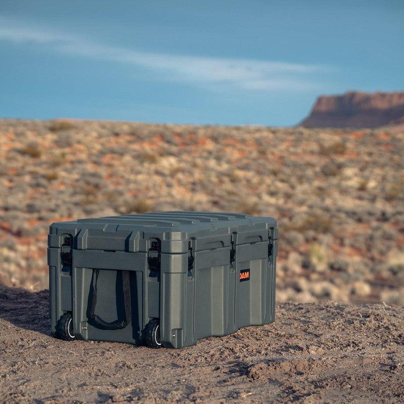 roam-125l-rolling-rugged-case-slate-corner-front-view-on-terrain