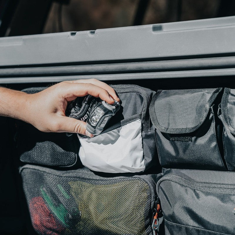 roam-95l-lid-organizer-clpse-up-view-on-rugged-case-with-hand-in-nature