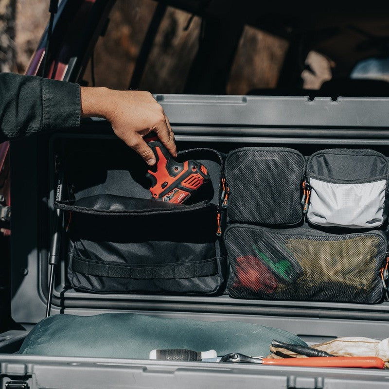 roam-95l-lid-organizer-clpse-up-view-on-rugged-case-with-hand-on-vehicle