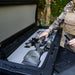 roam-95l-rugged-case-foam-insert-front-corner-view-in-rugged-case-with-person-in-nature
