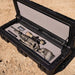roam-95l-rugged-case-foam-insert-front-corner-view-in-rugged-case-with-rifle-on-desert