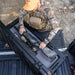 roam-95l-rugged-case-foam-insert-rear-corner-view-in-rugged-case-with-person-with-weapon-in-nature