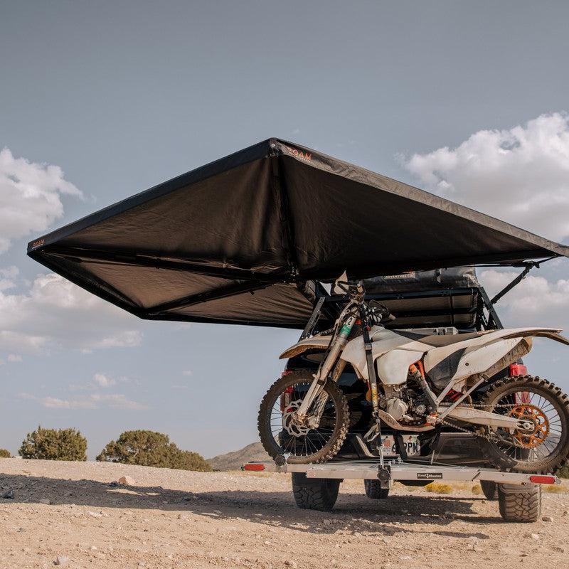 roam-arc-270-awning-driver-side-open-interior-view-with-motorcyle-in-nature