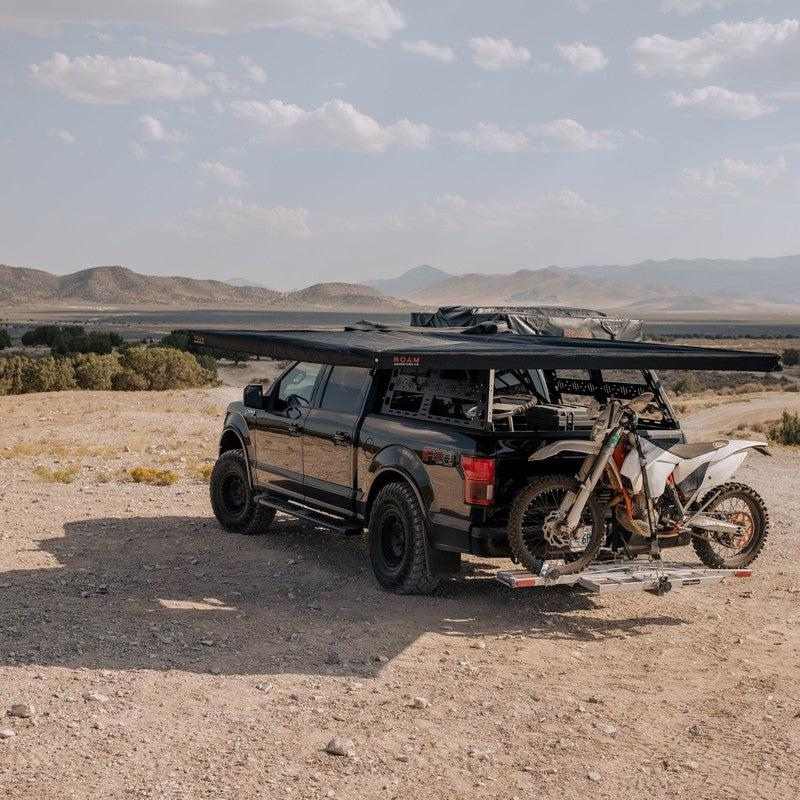 roam-arc-270-awning-driver-side-open-rear-view-with-motorcyle-in-nature