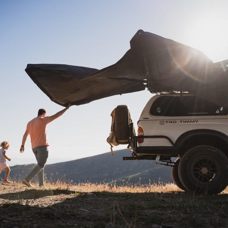 roam-arc-270-awning-passenger-side-open-side-view-with-person-opening-awning-in-nature