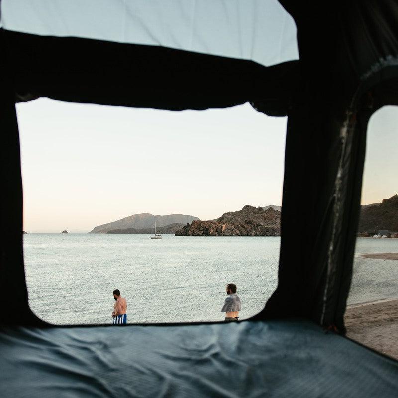 roam-desperado-hardshell-rooftop-tent-open-interior-view-with-mesh-window-covers-at-the-beach
