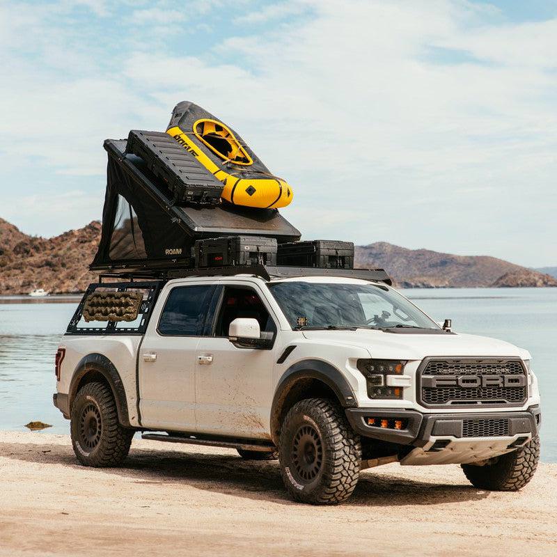 roam-desperado-hardshell-rooftop-tent-open-rear-corner-view-with-roam-case-in-nature