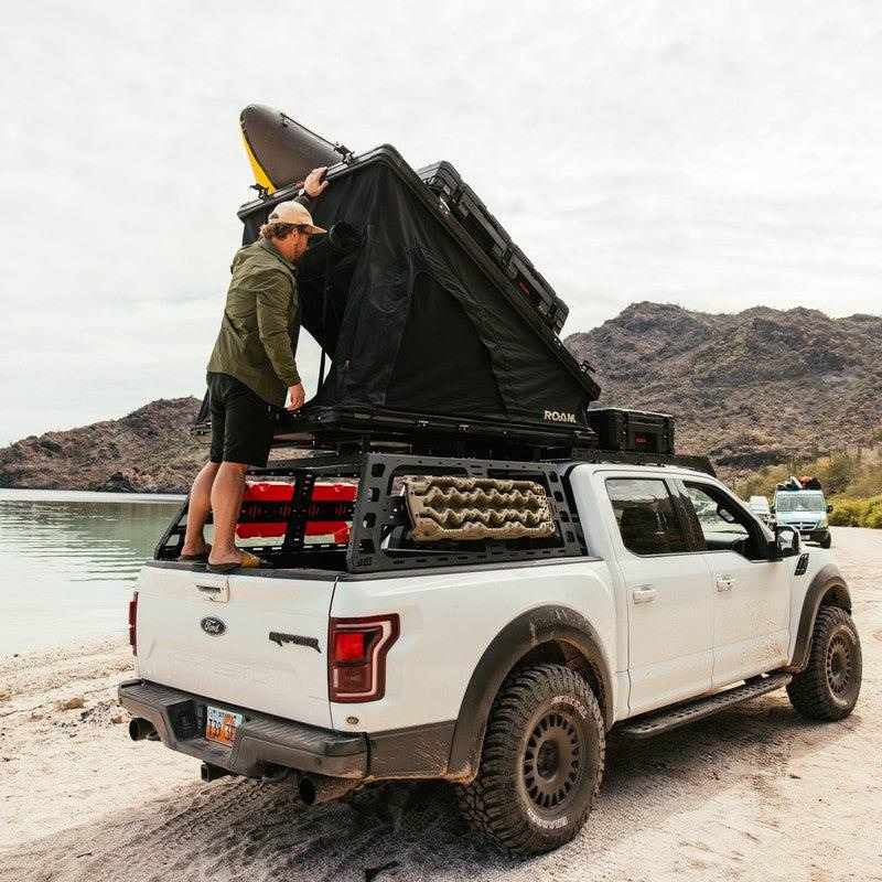 roam-desperado-hardshell-rooftop-tent-open-side-view-on-ford-raptor-with-person-in-nature