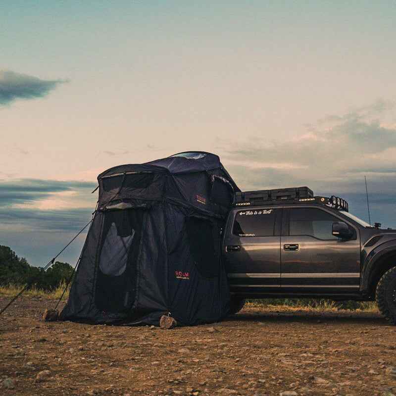 roam-vagabond-tent-annex-room-black-open-front-corner-view-on-vehicle-in-nature