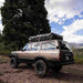roam-vagabond-xl-rooftop-tent-closed-front-corner-view-on-toyota-land-cruiser-in-nature