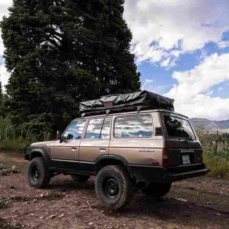 roam-vagabond-xl-rooftop-tent-closed-front-corner-view-on-toyota-land-cruiser-in-nature