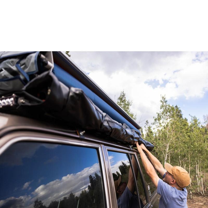 roam-vagabond-xl-rooftop-tent-slate-gray-navy-blue-closed-close-up-view-with-person-in-nature