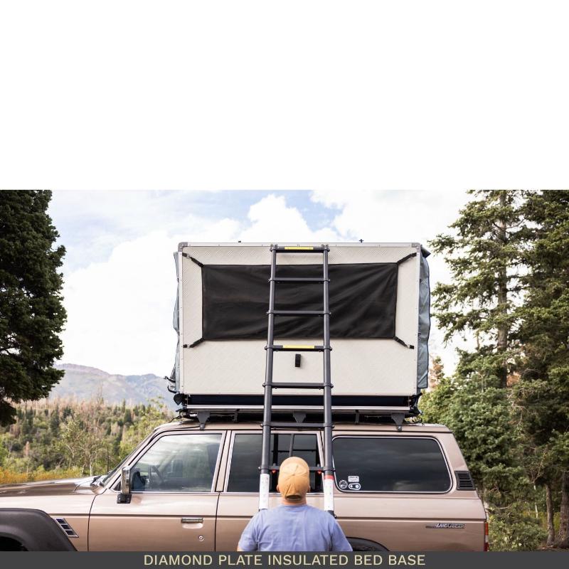 roam-vagabond-xl-rooftop-tent-slate-gray-navy-blue-closed-front-view-on-toyota-land-cruiser-with-diamond-plate-base-in-nature