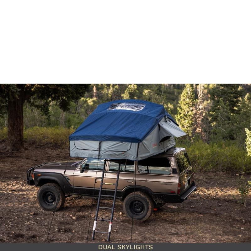 roam-vagabond-xl-rooftop-tent-slate-gray-navy-blue-open-front-corner-view-on-toyota-land-cruiser-with-dual-skylights-in-nature