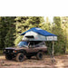roam-vagabond-xl-rooftop-tent-slate-gray-navy-blue-open-front-corner-view-on-toyota-land-cruiser-with-ladder-in-nature